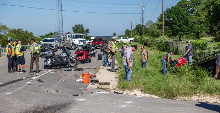 Group of people standing around a Motorcycle accidnet