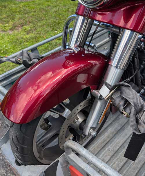 Image of Securing the Front One Strap on Each Side of a Motorcycle